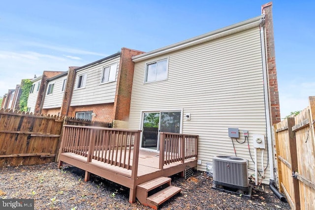 1214 Barnaby Ter SE, Washington, DC 20032 - back of house featuring central AC, a fenced backyard, a deck, and brick siding