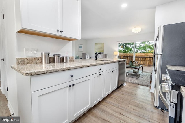 1214 Barnaby Ter SE, Washington, DC 20032 - kitchen featuring a sink, stainless steel appliances, light wood-style floors, and white cabinets