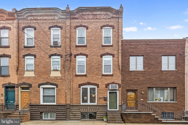 townhome / multi-family property featuring brick siding and cooling unit