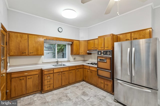 kitchen with appliances with stainless steel finishes, a sink, a warming drawer, light countertops, and ornamental molding