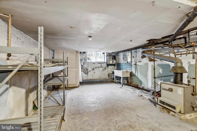basement with electric panel and a sink