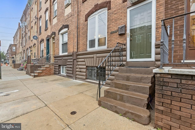 view of exterior entry featuring brick siding
