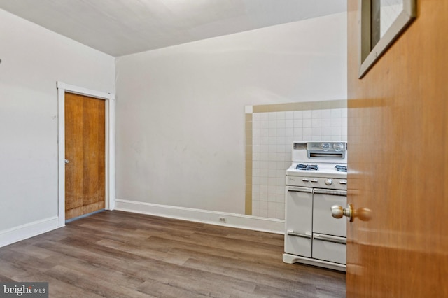 kitchen with white range with gas cooktop, wood finished floors, and baseboards