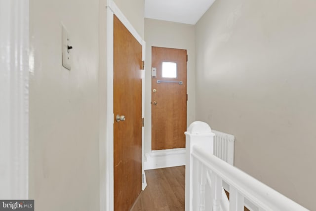 corridor featuring wood finished floors and an upstairs landing