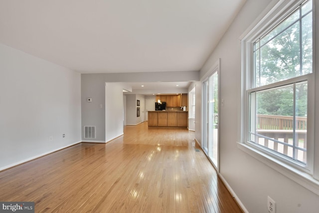 unfurnished living room featuring light wood-style flooring and baseboards