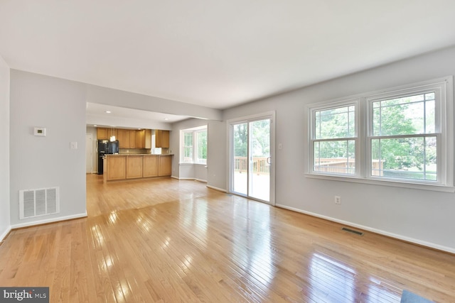 unfurnished living room featuring baseboards and light wood-style floors
