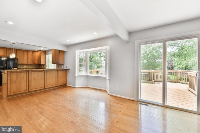 kitchen with brown cabinetry, baseboards, light wood-style floors, a peninsula, and pendant lighting
