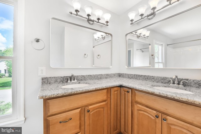 full bathroom featuring healthy amount of natural light and double vanity