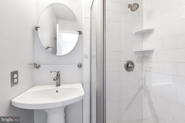 full bathroom featuring a stall shower and a sink