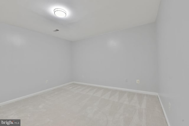 spare room with light carpet and baseboards