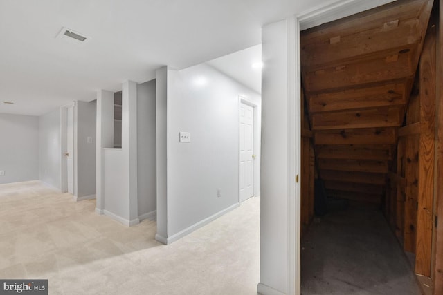 corridor featuring light carpet and baseboards