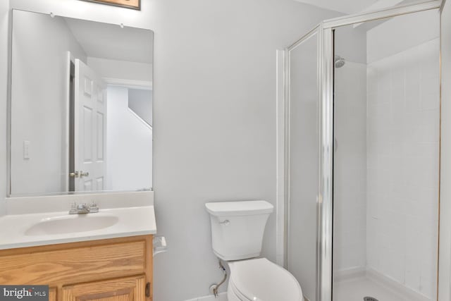 bathroom with a shower stall, toilet, and vanity