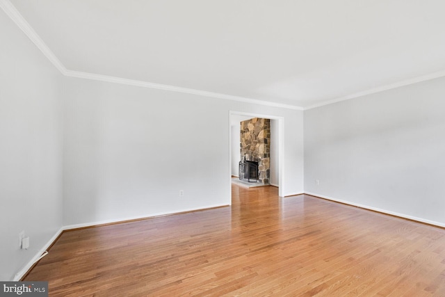 empty room with ornamental molding, wood finished floors, and baseboards