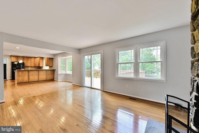 unfurnished living room with baseboards, light wood-style flooring, and recessed lighting