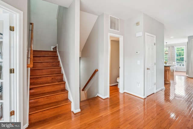 stairway featuring wood-type flooring and baseboards