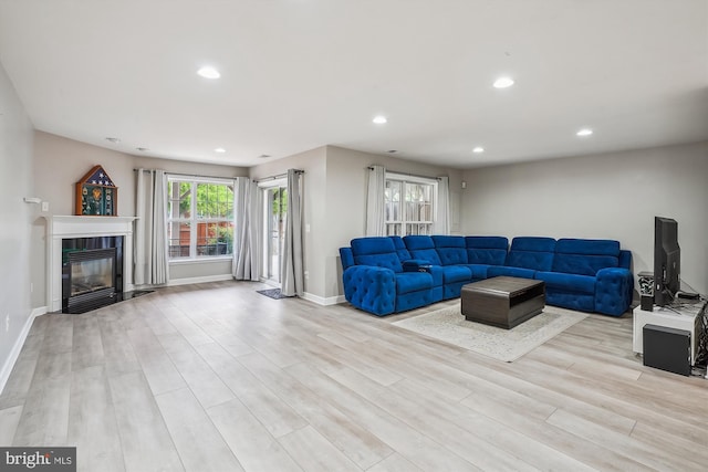 living room featuring light wood-type flooring, recessed lighting, a fireplace, and baseboards