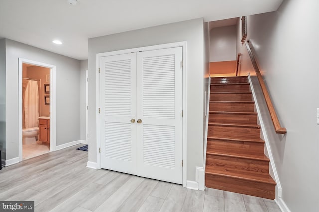 staircase with recessed lighting, wood finished floors, and baseboards