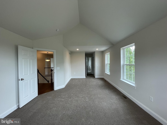 empty room featuring dark colored carpet, vaulted ceiling, baseboards, and recessed lighting