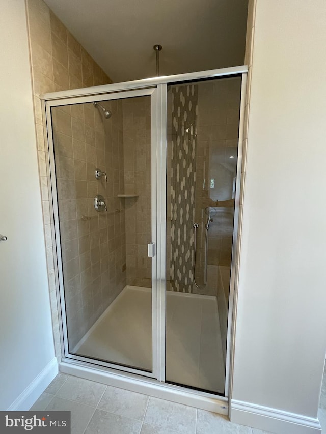 full bathroom featuring a shower stall, baseboards, and tile patterned floors