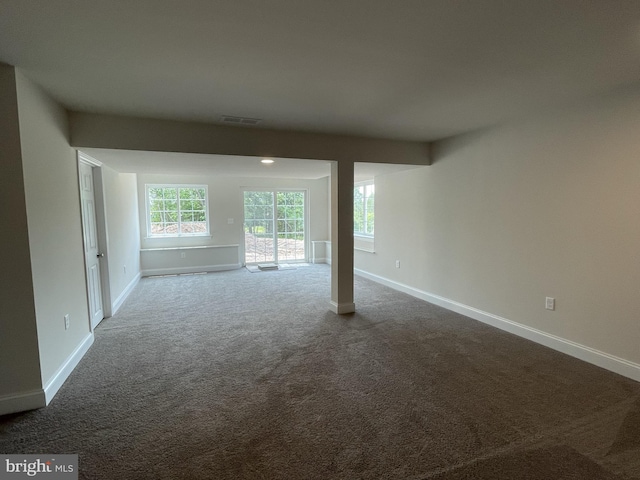 spare room with dark colored carpet and baseboards