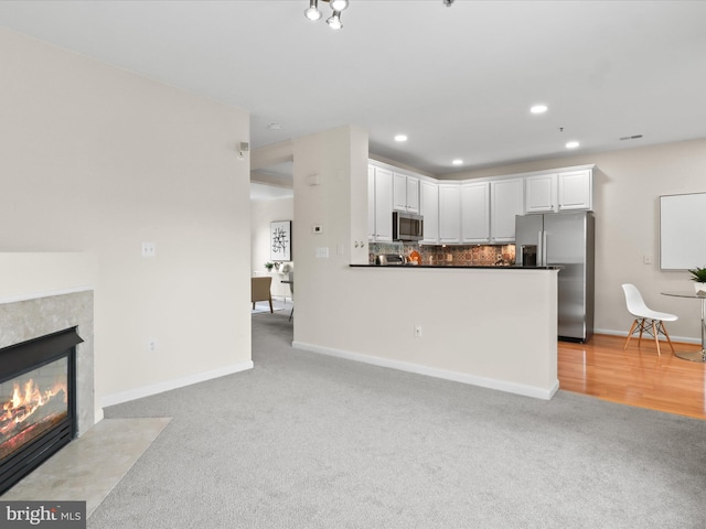 1604 Hunting Creek Dr Unit B, Alexandria, VA 22314 - kitchen featuring stainless steel appliances, light colored carpet, dark countertops, white cabinetry, and tasteful backsplash