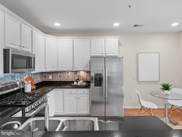 1604 Hunting Creek Dr Unit B, Alexandria, VA 22314 - kitchen featuring stainless steel appliances, white cabinetry, decorative backsplash, baseboards, and dark stone counters