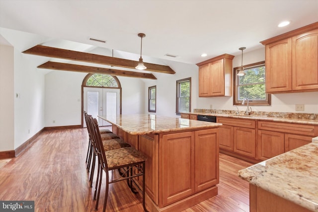 3789 Stump Rd, Doylestown, PA 18902 - kitchen featuring a sink, a center island, light stone counters, light wood finished floors, and black dishwasher