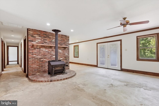 3789 Stump Rd, Doylestown, PA 18902 - unfurnished living room with concrete flooring, baseboards, a wood stove, ornamental molding, and french doors