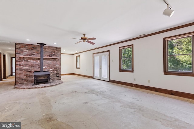 3789 Stump Rd, Doylestown, PA 18902 - unfurnished living room with baseboards, a wood stove, concrete floors, plenty of natural light, and crown molding