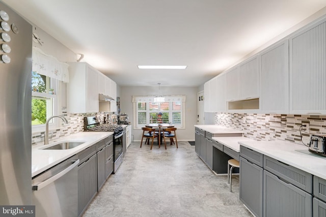 5101 Ampthill Dr, Alexandria, VA 22312 - kitchen with appliances with stainless steel finishes, a sink, gray cabinets, backsplash, and under cabinet range hood