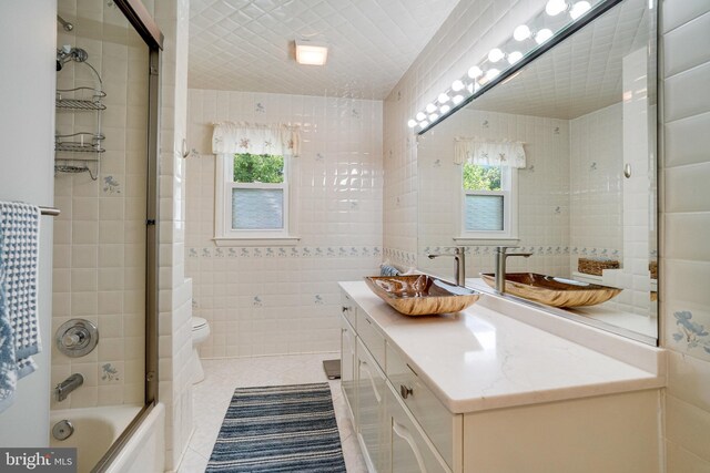 5101 Ampthill Dr, Alexandria, VA 22312 - bathroom featuring tile walls, tile patterned flooring, vanity, toilet, and tub / shower combination