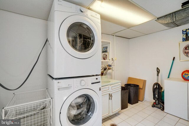 5101 Ampthill Dr, Alexandria, VA 22312 - washroom featuring cabinet space, stacked washer / drying machine, and light tile patterned floors