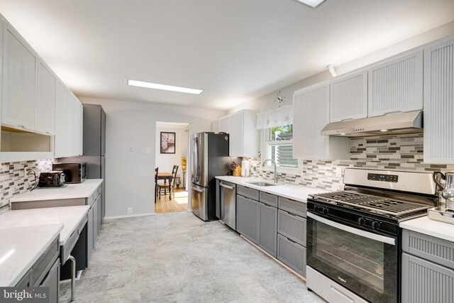 5101 Ampthill Dr, Alexandria, VA 22312 - kitchen featuring appliances with stainless steel finishes, under cabinet range hood, a sink, and gray cabinetry