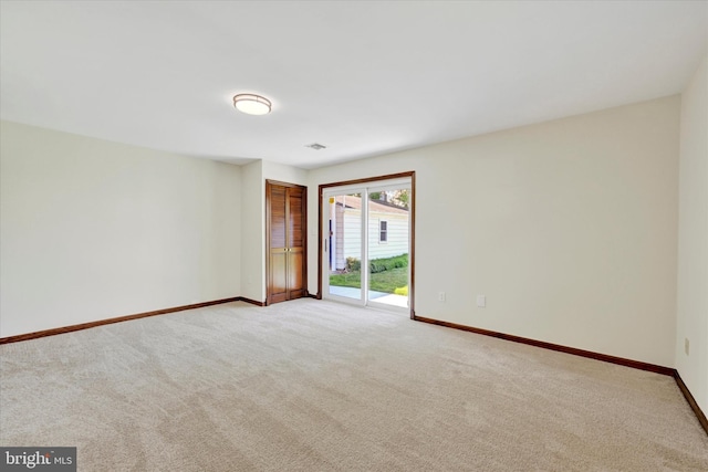 unfurnished room featuring light carpet and baseboards