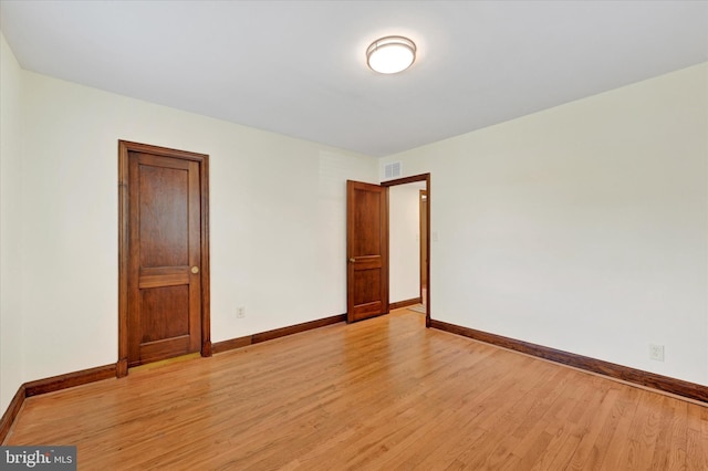 spare room with light wood finished floors and baseboards