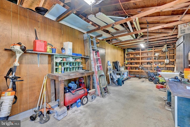 garage with wooden walls and a workshop area