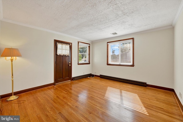 entrance foyer with a baseboard radiator, a textured ceiling, light wood-type flooring, baseboards, and crown molding