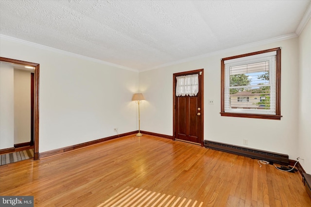 foyer entrance with light wood-style floors, baseboards, crown molding, baseboard heating, and a textured ceiling