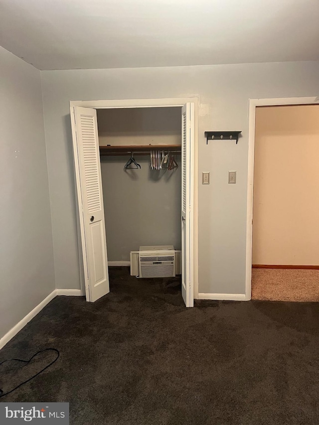 313 Northfield Ave, Waynesboro, PA 17268 - unfurnished bedroom with dark colored carpet, a closet, an AC wall unit, and baseboards