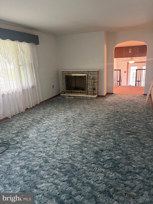 313 Northfield Ave, Waynesboro, PA 17268 - unfurnished living room featuring a fireplace with raised hearth, arched walkways, carpet floors, and baseboards