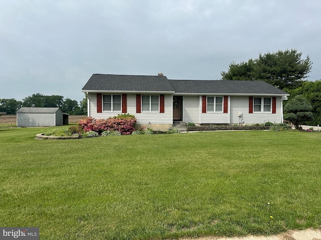 single story home featuring an outdoor structure, a shed, and a front lawn