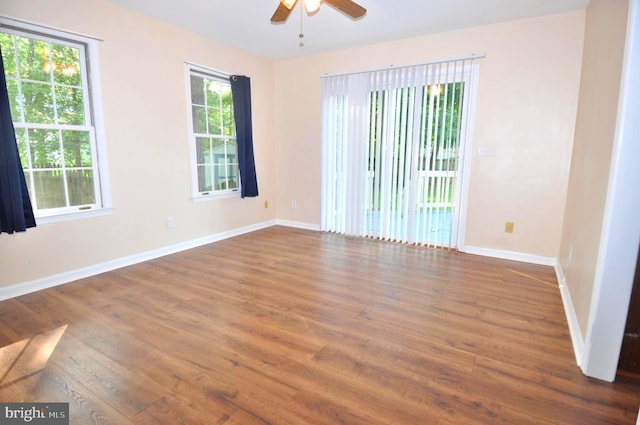 unfurnished room featuring ceiling fan, wood finished floors, and baseboards