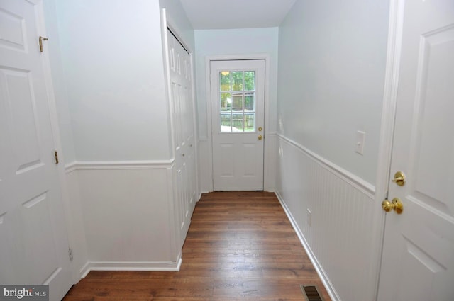 entryway featuring wood finished floors, wainscoting, and a decorative wall