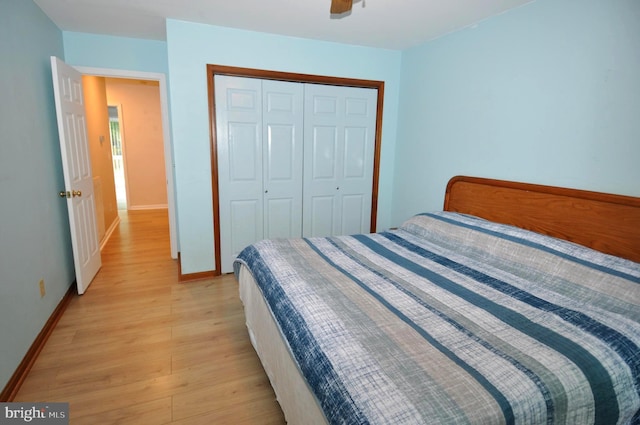 bedroom featuring light wood-style floors, baseboards, a closet, and a ceiling fan