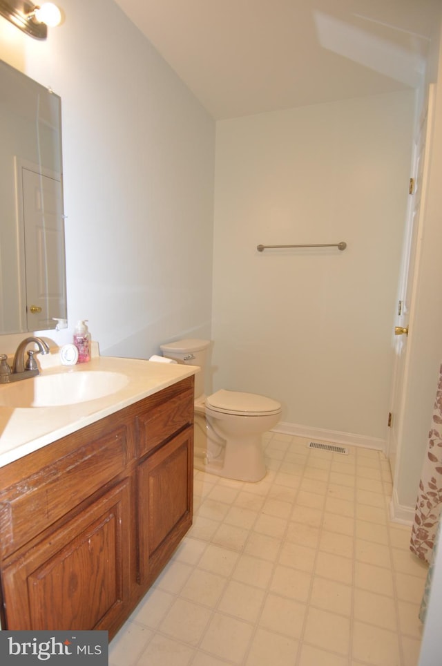 bathroom featuring tile patterned floors, vanity, and toilet