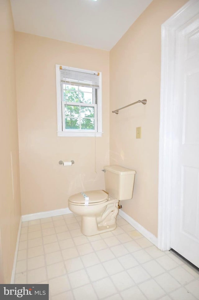 bathroom with toilet and baseboards