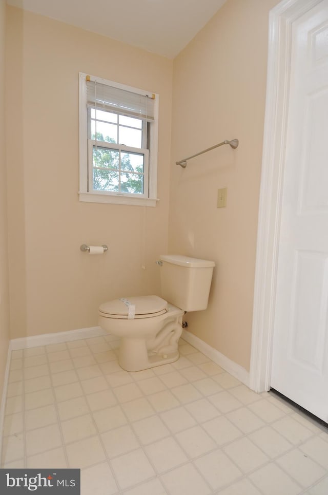 bathroom featuring baseboards and toilet