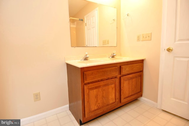 full bathroom with baseboards and double vanity