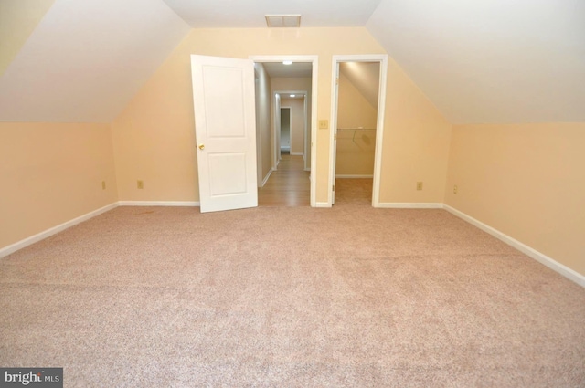 additional living space with carpet, vaulted ceiling, and baseboards