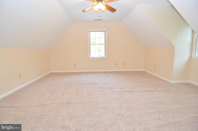 bonus room featuring a ceiling fan, light colored carpet, lofted ceiling, and baseboards